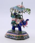 An Eastern unmarked white metal enamel decorated elephant and howdah. 8 cm high.