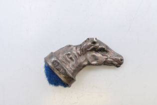 A silver horse's head form pin cushion. 3 cm wide.