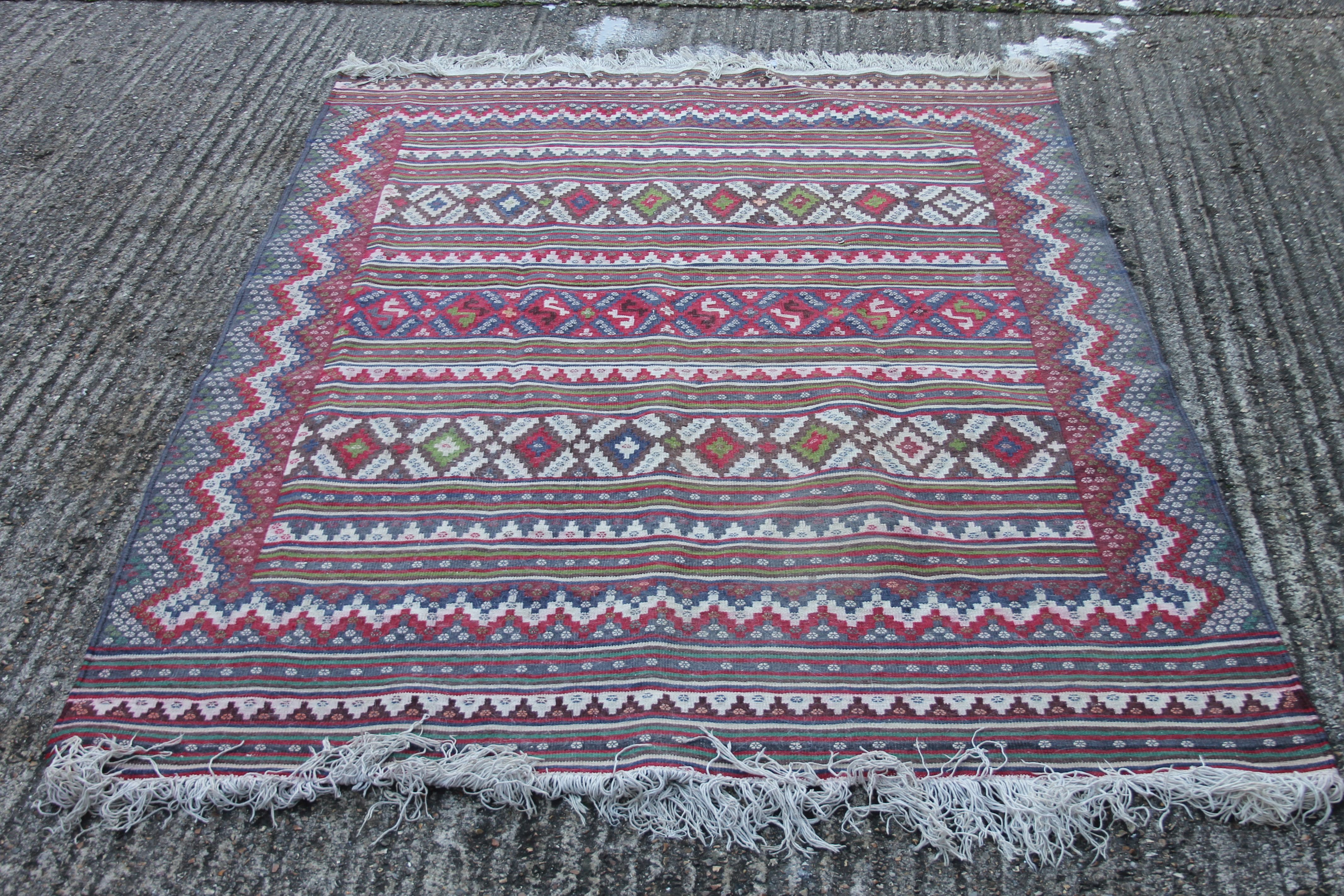 A red ground wool rug. 229 cm x 163 cm.