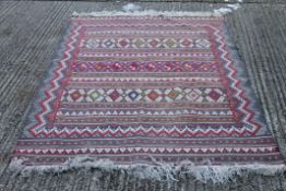 A red ground wool rug. 229 cm x 163 cm.