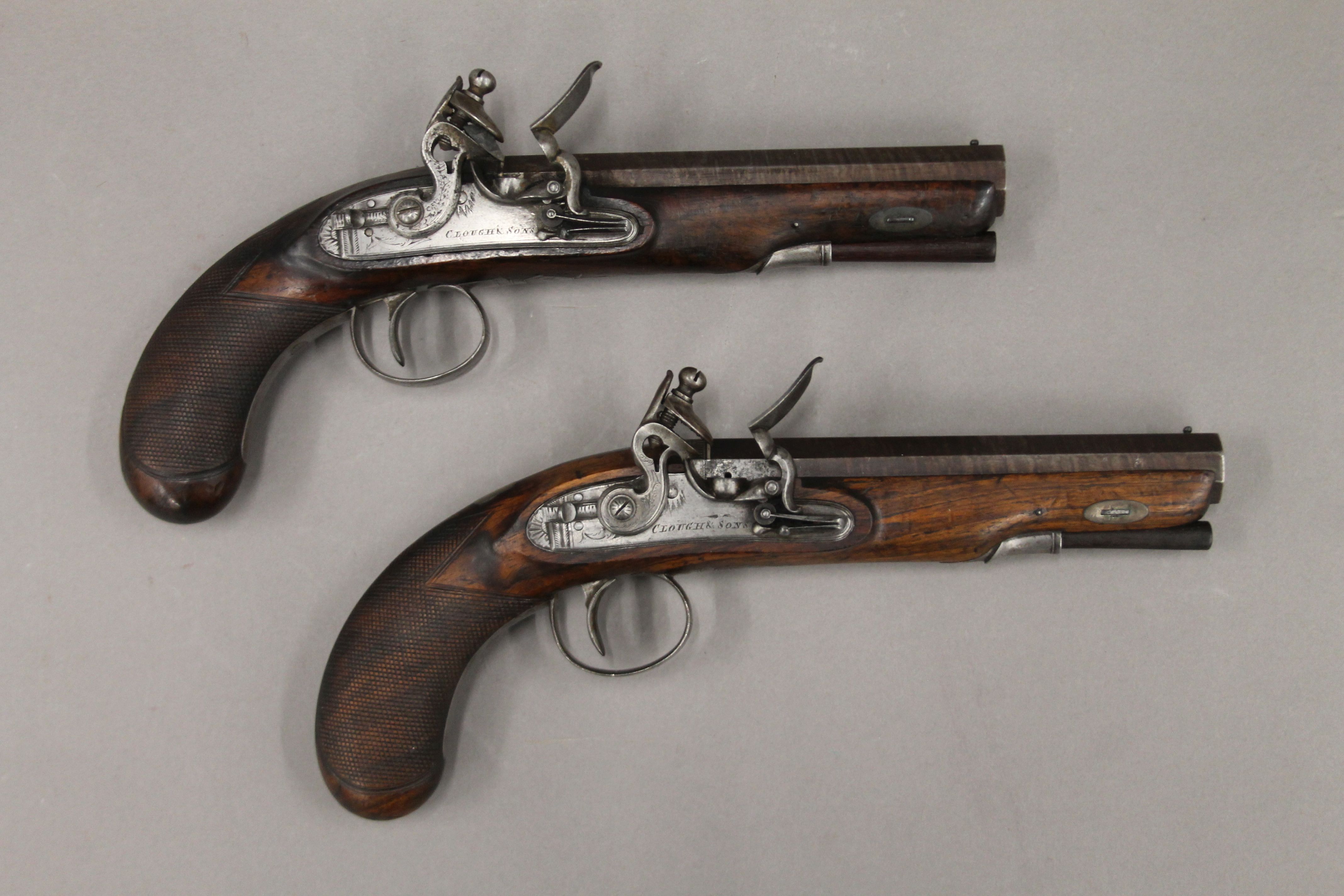 A pair of flintlock pistols by Clough & Sons. 27 cm long.