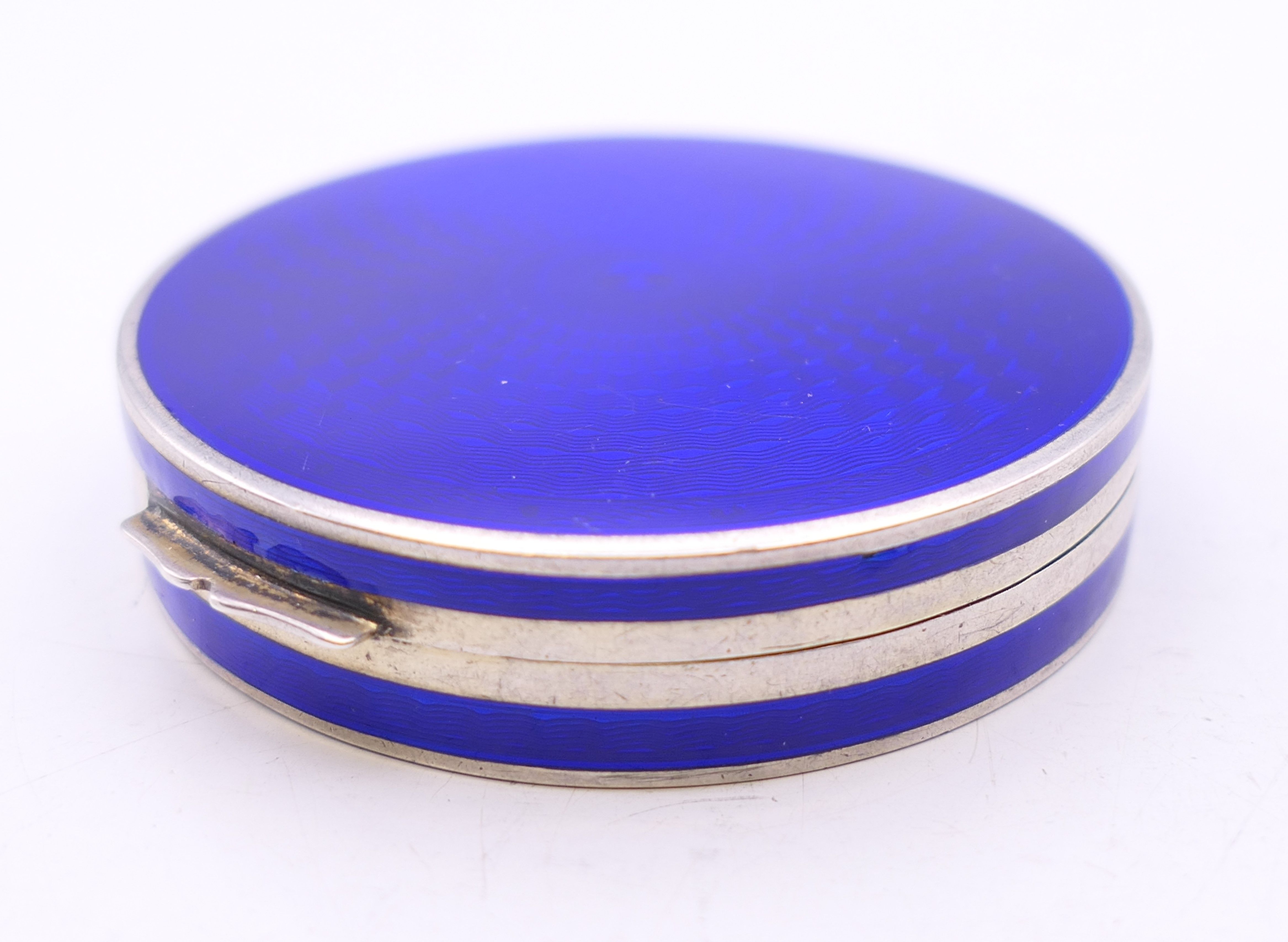 An enamel decorated silver compact. 5 cm diameter.