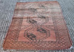 A red ground wool rug. 205 cm x 124 cm.