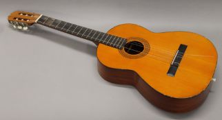 A cased acoustic guitar. 102 cm long.