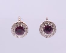 A pair of white gold ruby and diamond cluster earrings. 1 cm diameter.