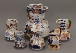 A large Masons Ironstone jug and a quantity of other jugs. The former 24 cm high.