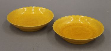 A pair of Chinese Qianlong yellow glazed dishes incised with two dragons chasing flaming pearls