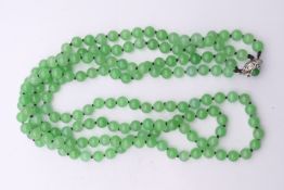 An 18 ct white gold mounted two strand jade bead necklace. 72 cm long.