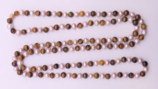 A string of tigerseye and pearls. 120 cm long.