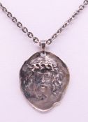A silver pendant on chain set with the bust of Christ. Pendant 3.5 cm high, chain 60 cm long.