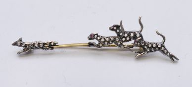 An unmarked gold and silver diamond set fox hunting brooch. 7 cm long. 4.1 grammes total weight.