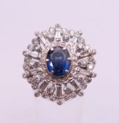 An 18 ct white gold sapphire and diamond cluster ring. Ring size O. 14 grammes total weight.