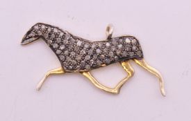 A horse shaped diamond set charm. 3 cm long.