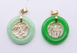 Two Chinese 14 ct gold mounted jade disc pendants. Each 2 cm diameter.