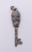 A diamond skeleton key form charm. 4 cm high.