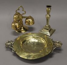 A brass ware candlestick, bells and a dish. The former 16.5 cm high.