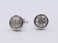A pair of 9 ct white gold diamond stud earrings, each stone spreading to approximately 1 carat. 0.