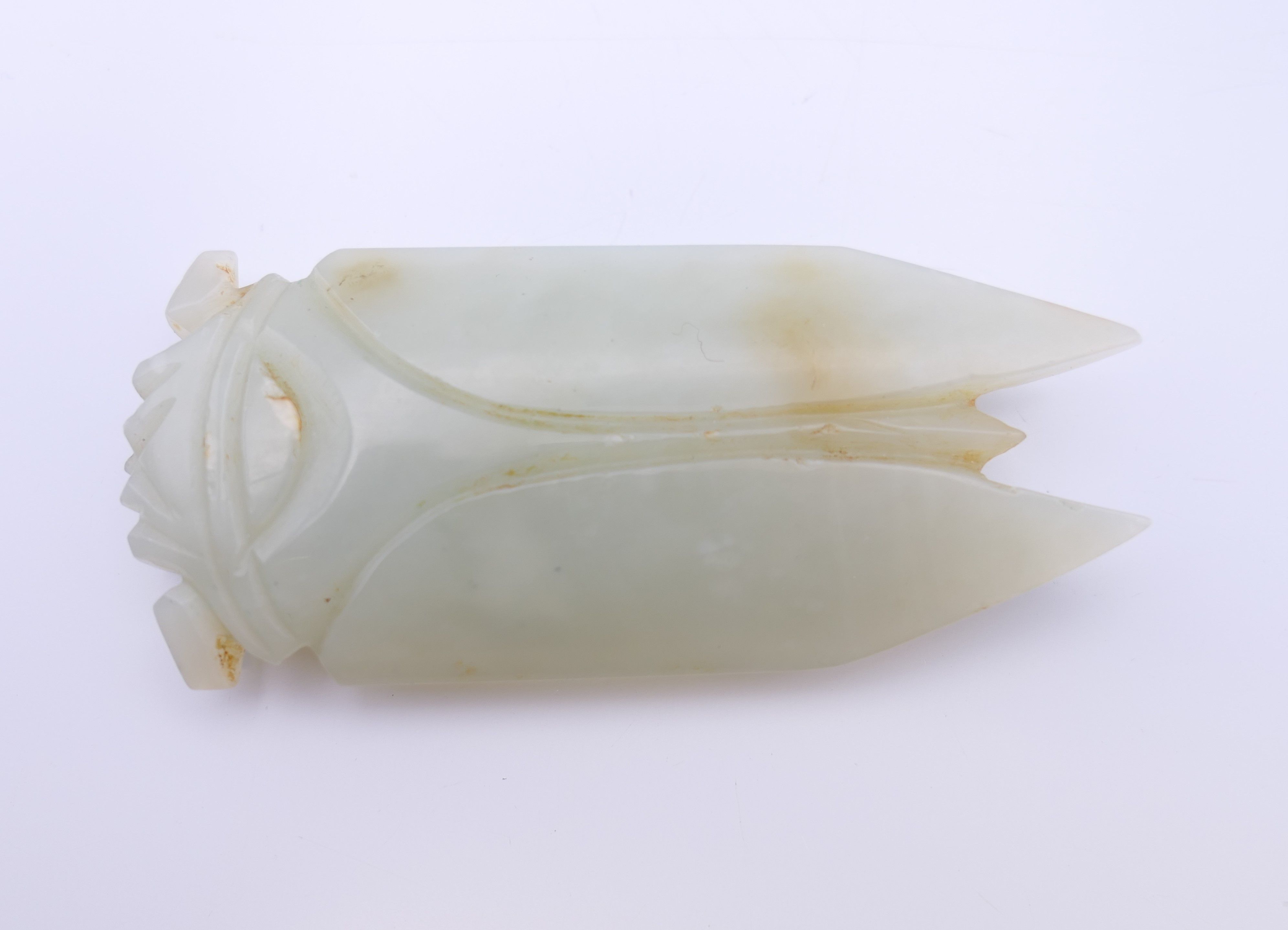 A Chinese light green jade cicada, Han Dynasty. 7 cm long. Provenance: The Larkin/Minney Collection.