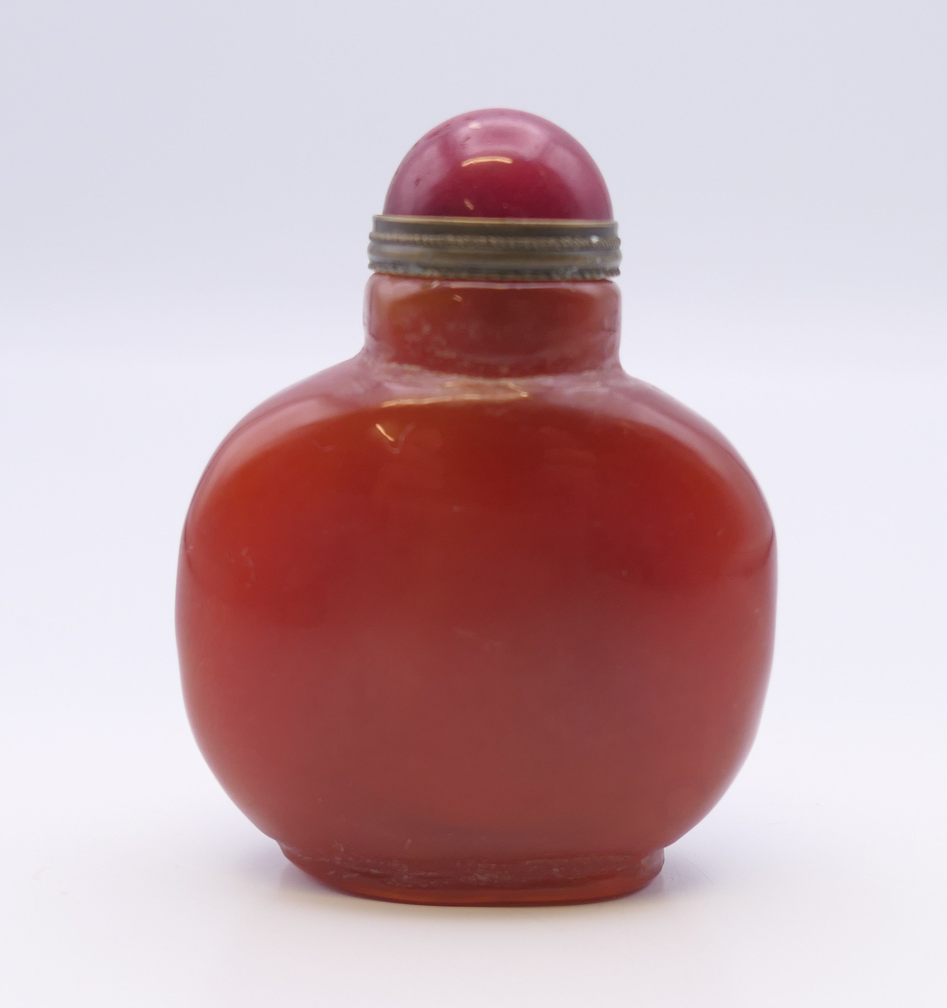 A small Chinese reddish brown agate snuff bottle, with red stopper. 5.5 cm high.