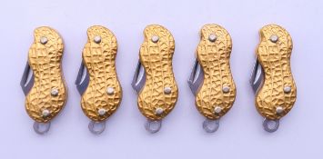 Five penknives each shaped as a peanut. Each 3.5 cm long, closed.