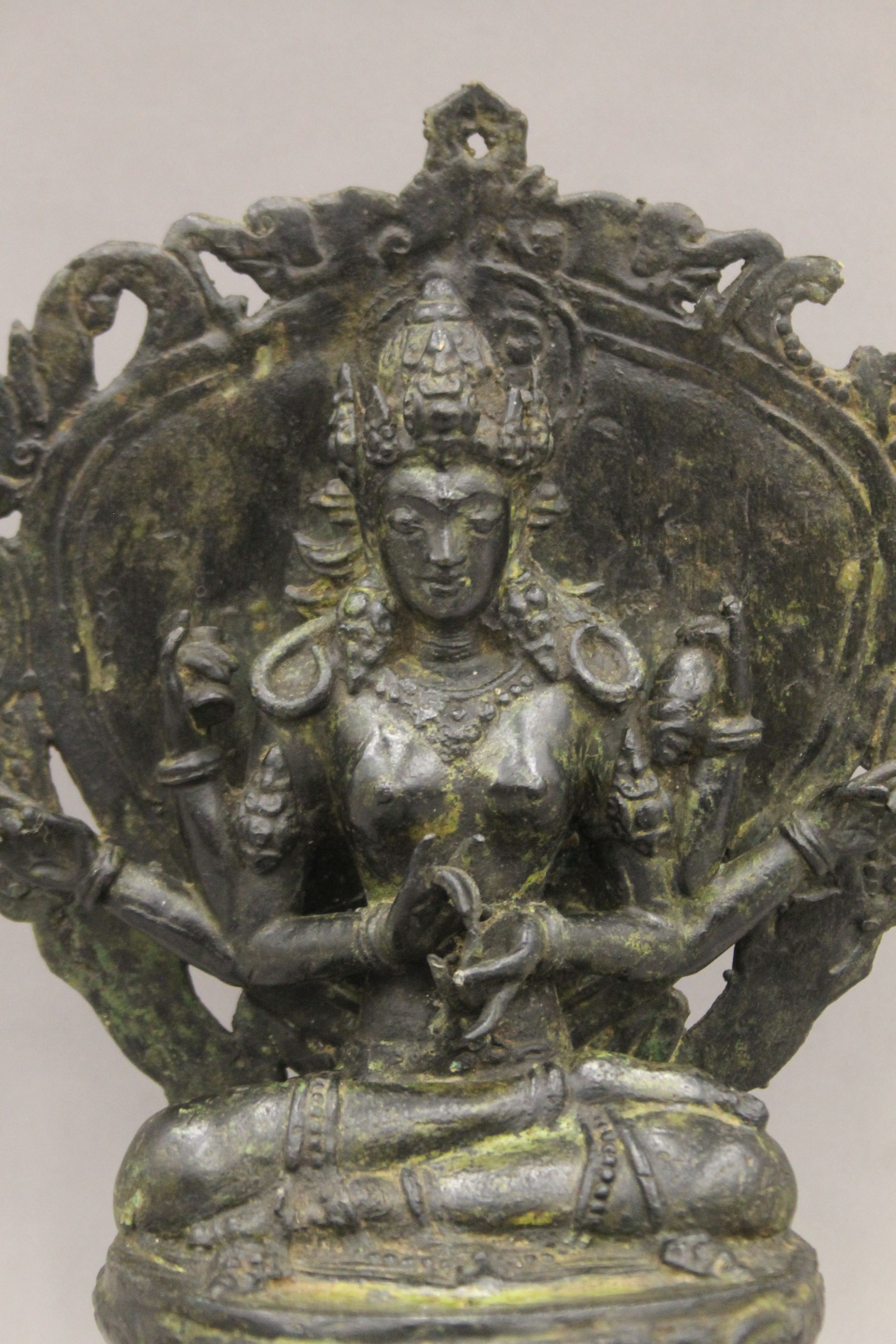 A Tibetan bronze figure of a six armed deity seated on a lotus leaf, on a stepped base. 34 cm high. - Image 2 of 5