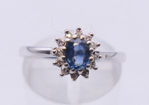 A 9 ct white gold sapphire and diamond cluster ring. Ring size M/N. 2.9 grammes total weight.