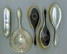A quantity of silver and tortoiseshell dressing table brushes and a mirror. The latter 27 cm long.