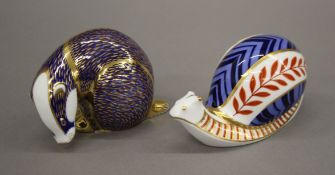 Two Royal Crown Derby paperweights - a snail and a badger. The former 13 cm long.