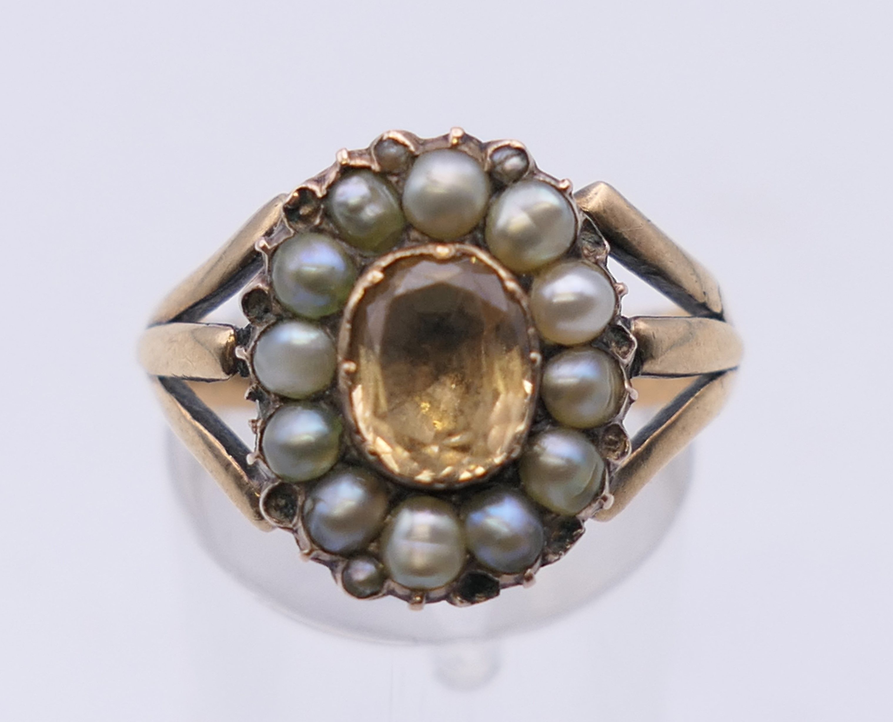 An antique unmarked gold Imperial topaz and seed pearl ring. Ring size N/O. 5.