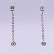 A pair of white gold and diamond drop earrings. 3 cm high.