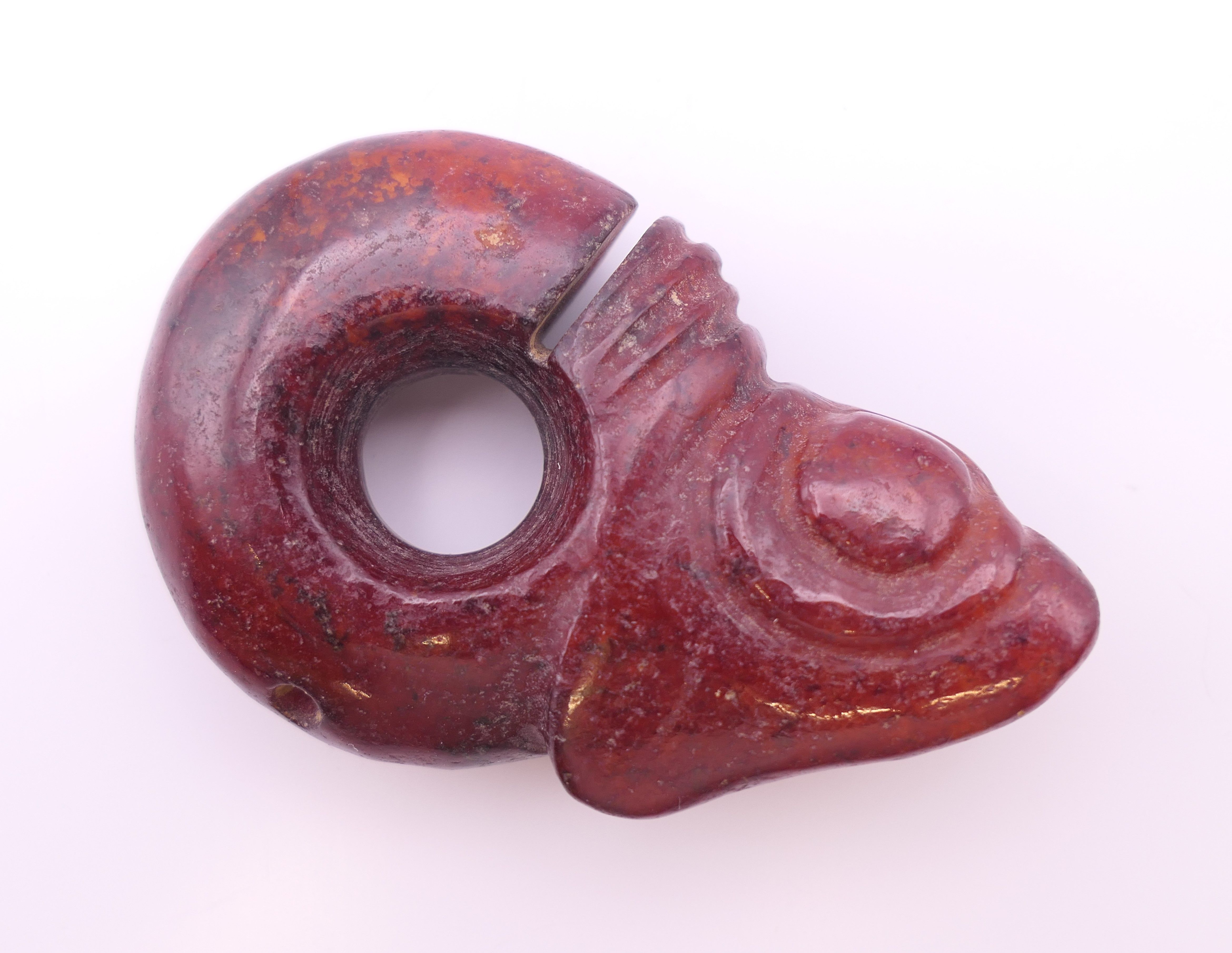 A Chinese red jade pig dragon, early Hongshan Culture. 6 cm long.