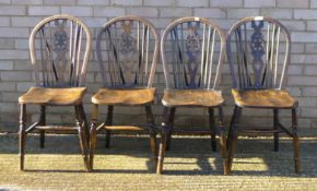A set of four elm seated wheel back chairs. 36 cm wide.