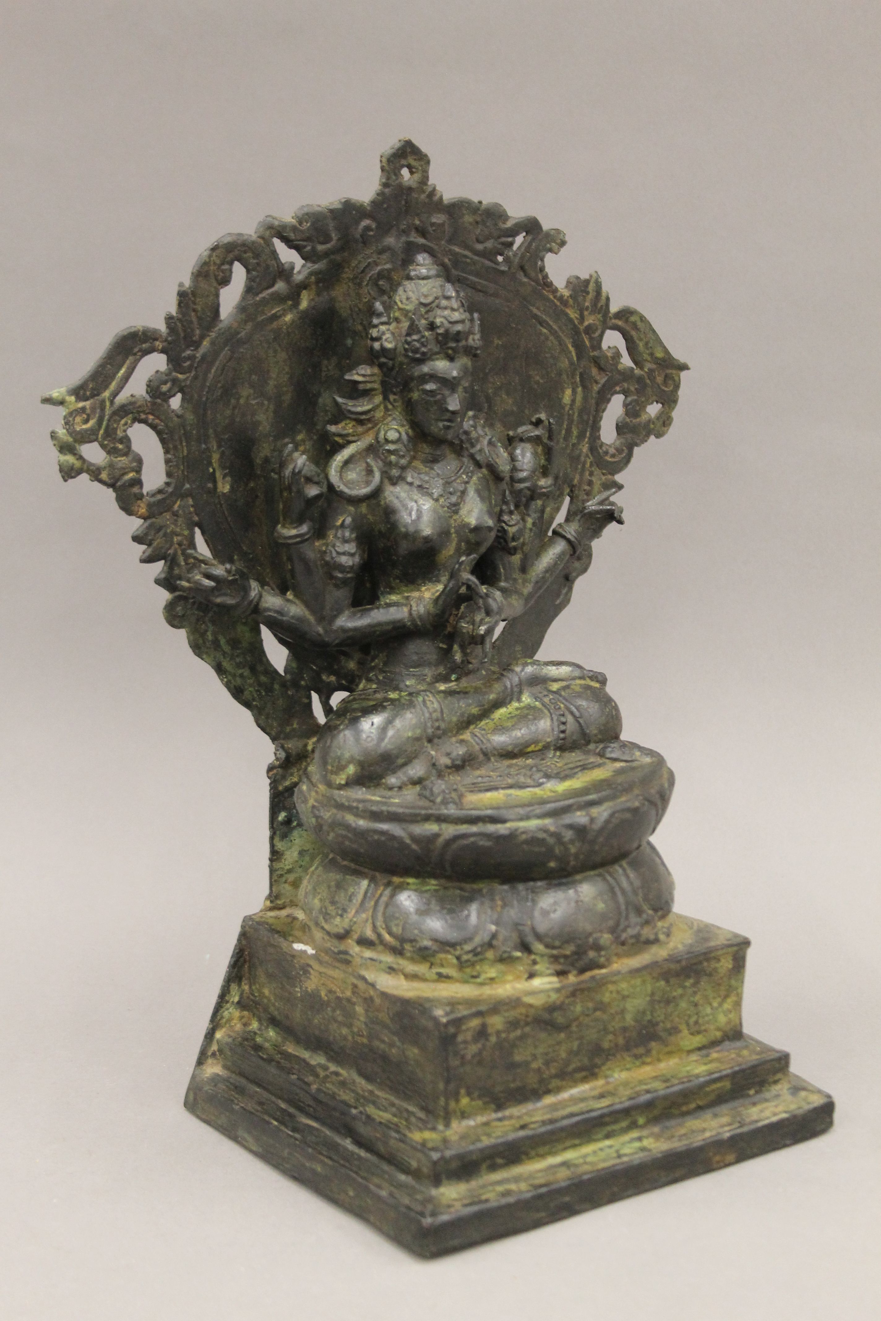 A Tibetan bronze figure of a six armed deity seated on a lotus leaf, on a stepped base. 34 cm high. - Image 3 of 5