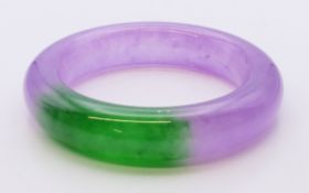 A two-tone jade bangle. 5.75 cm internal diameter.