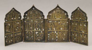 An 18th century or earlier Russian brass and enamel four panel folding icon. 16 cm high.