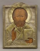 A 19th century Russian icon of St Nicholas painted on wooden panel, covered in a metal oclad. 24.