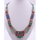 An unmarked silver turquoise and coral necklace. Approximately 50 cm long.