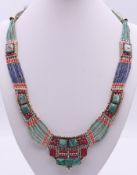 An unmarked silver turquoise and coral necklace. Approximately 50 cm long.