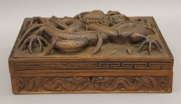 A late 19th century Eastern carved wooden box, the top carved with a dragon. 29 cm wide.