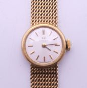 A ladies 9 ct gold Omega wristwatch. 1.75 cm wide. 20.8 grammes total weight.