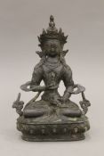 A Tibetan bronze of a seated Buddha, script to reverse. 19.5 cm high.