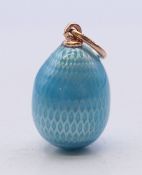 A 14 ct gold mounted blue enamel egg pendant, bearing Russian marks. 2 cm high.