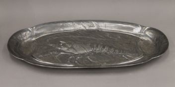A large pewter Art Nouveau lobster dish decorated with a lobster surrounded by small fish,