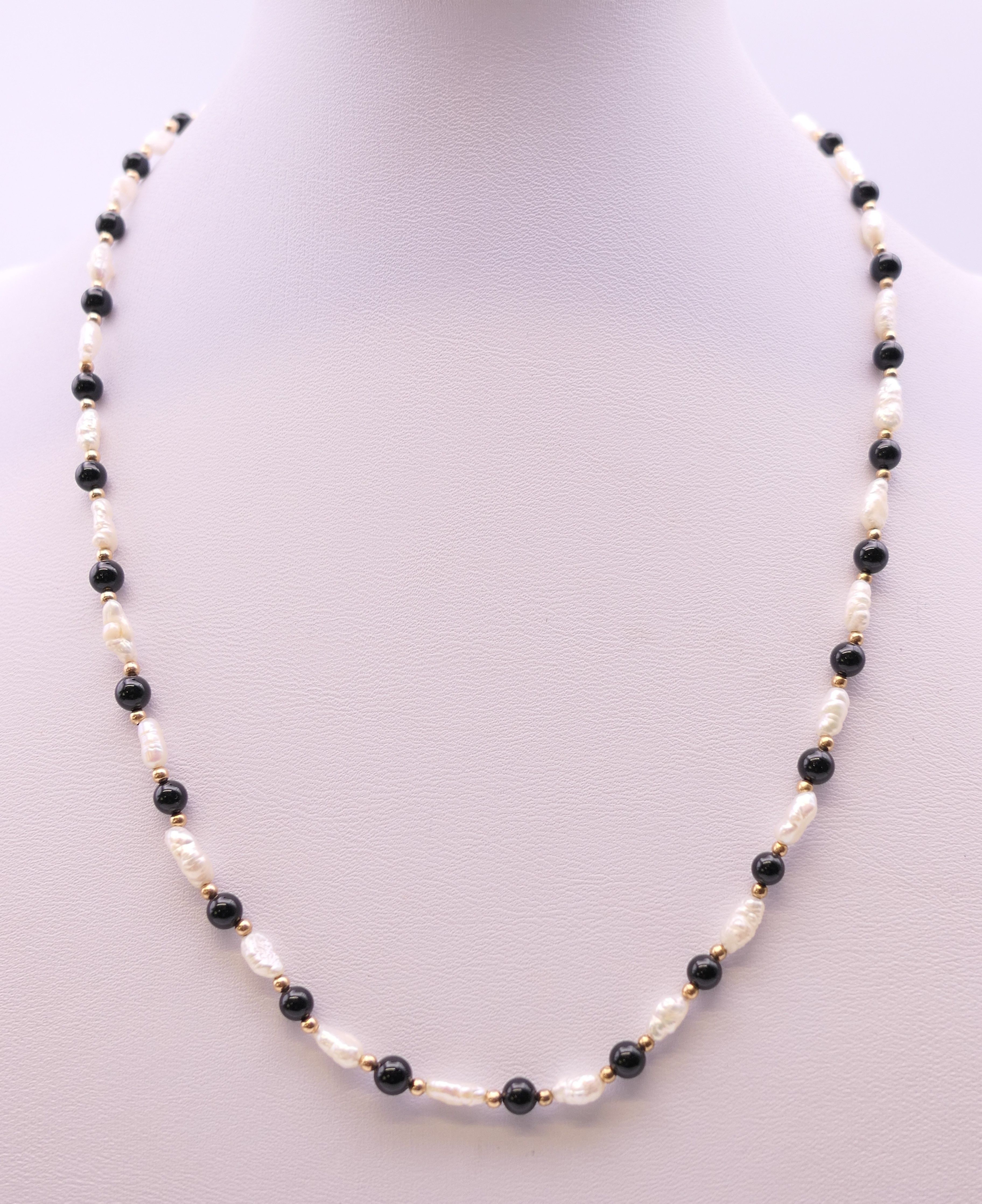 A pearl and black bead necklace with 9 ct gold clasp. 44 cm long.