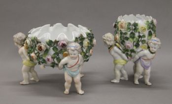 A pair of Sitzendorf porcelain baskets decorated with cherubs. The largest 18.5 cm high.