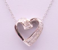 A white gold and diamond heart shaped pendant necklace. Pendant 1.75 cm high, chain 43 cm long.