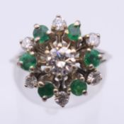 An 18 ct gold diamond and emerald ring. Ring size M. 5.8 grammes total weight.