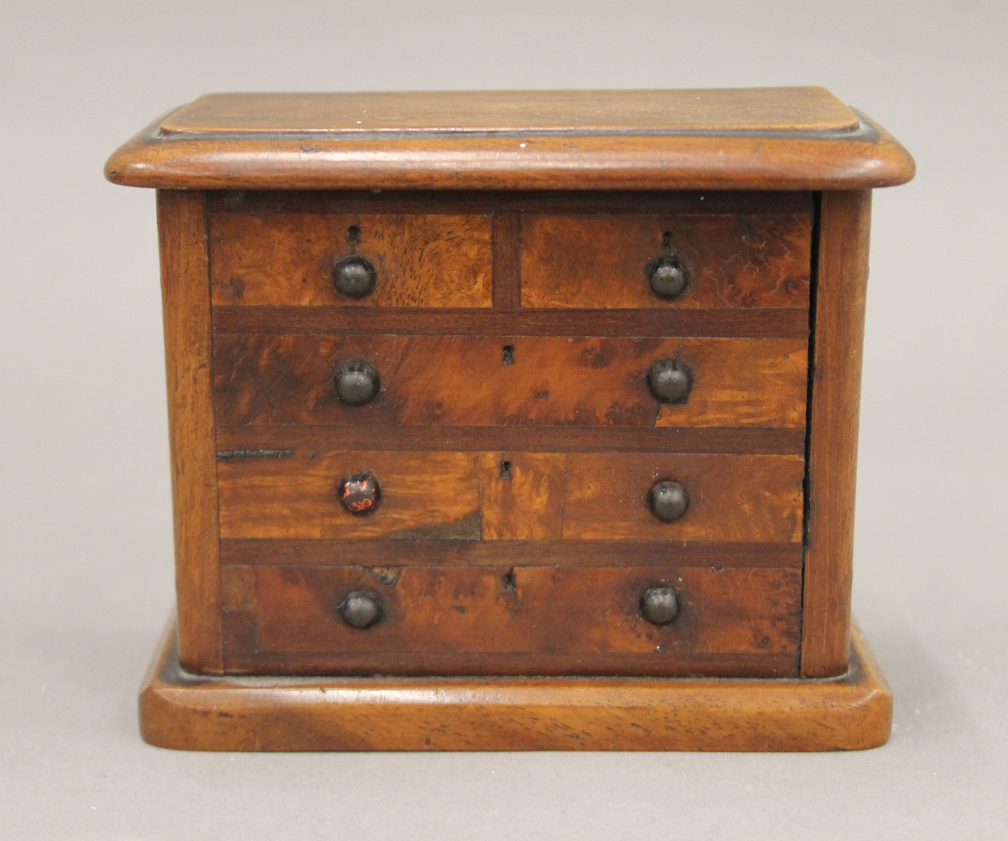 A money box formed as a Victorian chest of drawers. 12.5 cm wide.