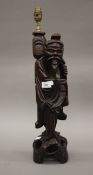 A Chinese carved hardwood table lamp of figural form. 57 cm high overall.