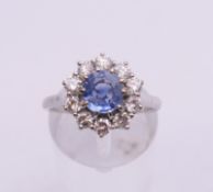 An unmarked 18 ct white gold sapphire and diamond circular cluster ring. Ring size O. 5.